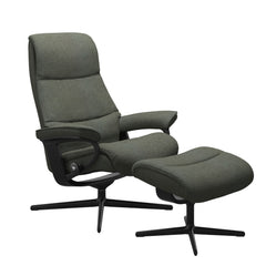 Stressless View, korkeaselkänojainen -lepotuoli ja rahi vihreänä: Green 90 Daisy -kangasverhoilulla ja mattamustalla Cross-metallijalustalla.