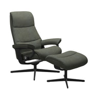 Stressless View, korkeaselkänojainen -lepotuoli ja rahi vihreänä: Green 90 Daisy -kangasverhoilulla ja mattamustalla Cross-metallijalustalla.