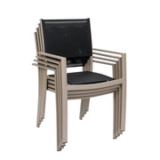 Suvituuli Kevyt -tuoli beigen/greigen värisellä rungolla ja mustilla istuinosilla. Pinottava malli menee pieneen tilaan varastossa.