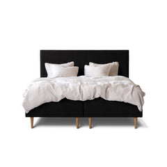 Tempur Break Box -runkosänkypaketti mustalla verhoilulla ja tammijaloilla. Kuvan Tempur Break Classic -sängynpääty ja petivaatteet myydään erikseen.