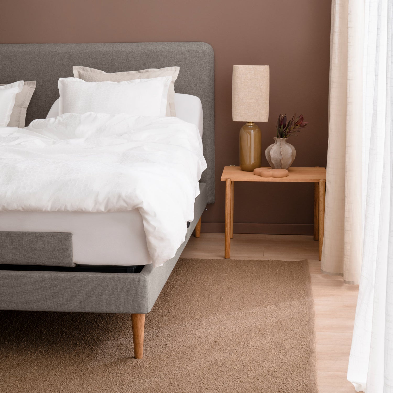 Lähikuvassa on Tempur Move-säätövuode parisänkypakettina tummanhiekanvärisellä Warm Stone -kankaalla verhoiltuna ja Tempur Pro 21 SmartCool patjoilla, sekä luonnonvärisillä tammijaloilla. Kuvan sängynpääty ja petivaatteet myydään erikseen.