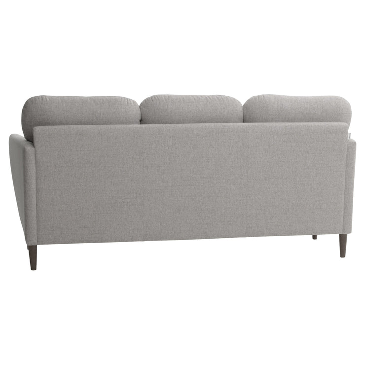 Taru 3-istuttava sohva vaalealla hiekanvärisellä Taste 13 -verhoilukankaalla ja pähkinänvärisillä puujaloilla. Sohva on kauttaaltaan verhoiltu huolellisesti.