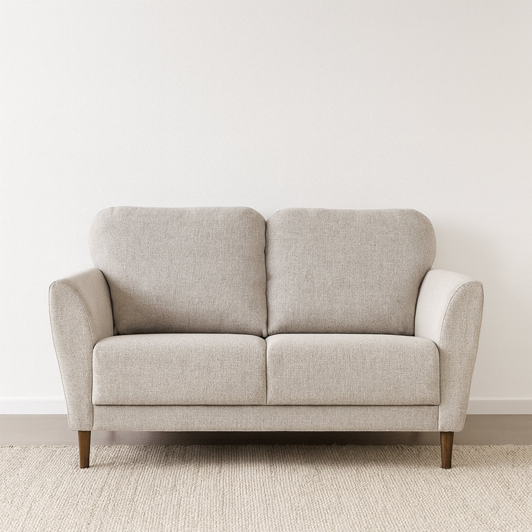 Taru 2-istuttava sohva vaalealla hiekanvärisellä Taste 13 -verhoilukankaalla ja pähkinänvärisillä puujaloilla. Stailattu visualisointi.