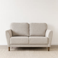 Taru 2-istuttava sohva vaalealla hiekanvärisellä Taste 13 -verhoilukankaalla ja pähkinänvärisillä puujaloilla. Stailattu visualisointi.