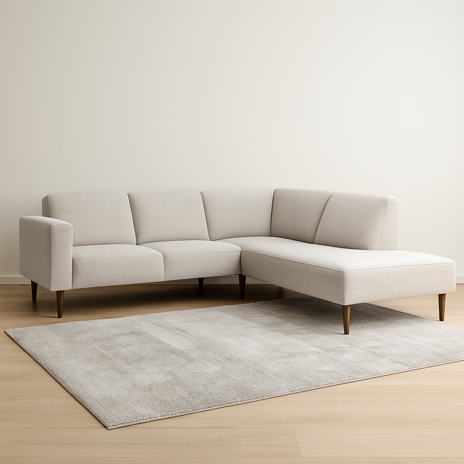 Oikeanpuoleinen divaallinen Tessa-avokulmasohva vaalealla hiekanvärisellä Taste 13 -kankaalla, 20 cm leveällä käsinojalla ja pähkinänvärisillä 18 cm pyöreäkartiopuujaloilla. Stailattu visualisointi.