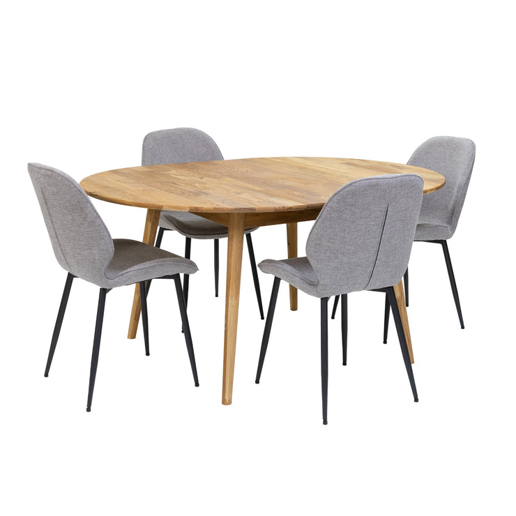 Luonnonvärinen pyöreä Vera-tammipöytä jatkettuna 40 cm jatkolevyllä ja harmaat kangasverhoillut Cordova-tuolit mustilla metallijaloilla. Ruokaryhmäpakettiin kuuluu 6 tuolia.