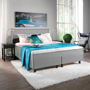 Kuvassa on vaaleanharmaa Aallotar-jenkkisänkypaketti, johon sisältyvät profiloitu sijauspatja ja mustat puujalat. Kuvan Aalto-sängynpääty myydään erikseen.