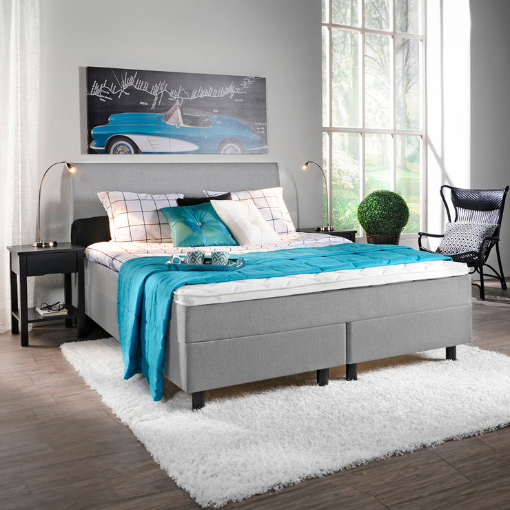 Kuvassa on vaaleanharmaa Aallotar-jenkkisänkypaketti, johon sisältyvät profiloitu sijauspatja ja mustat puujalat. Kuvan Aalto-sängynpääty myydään erikseen.