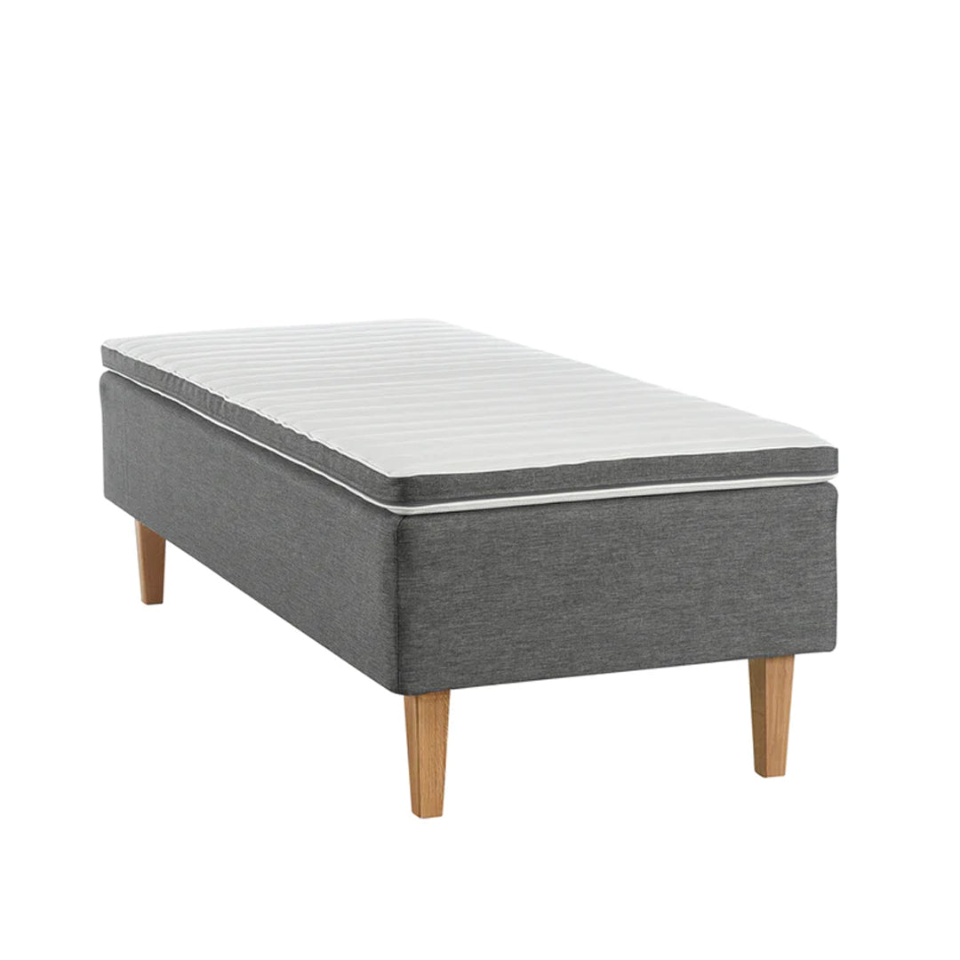 Antrasiitin värinen Aava-runkopatja luonnonvärisillä Royal-tammijaloilla ja profiloidulla sijauspatjalla.