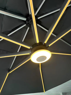 Aurinkovarjon Bluetooth-kaiutin, kuvattuna erikseen myytävän varjon alla/sisäpuolella. Kaiuttimessa on myös säädettävä LED-valo.