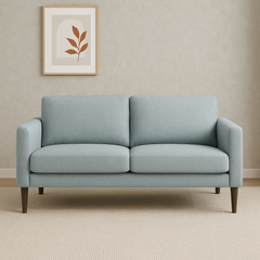 Kuvassa on Ilona 2-istuttava sohva jäänharmaalla/mintun värisellä Naomi 347 -kankaalla ja wengen värisillä 18 cm korkeilla pyöreäkartiojaloilla.  Kuvan sohvassa on 10 cm leveät KN10-käsinojat. Stailattu visualisointi.