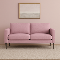 Kuvassa on Ilona 2-istuttava sohva vaaleanpunaisella Naomi 324 -kankaalla ja wengen värisillä 18 cm korkeilla pyöreäkartiojaloilla. Kuvan sohvassa on 10 cm leveät KN10-käsinojat. Stailattu visualisointi.