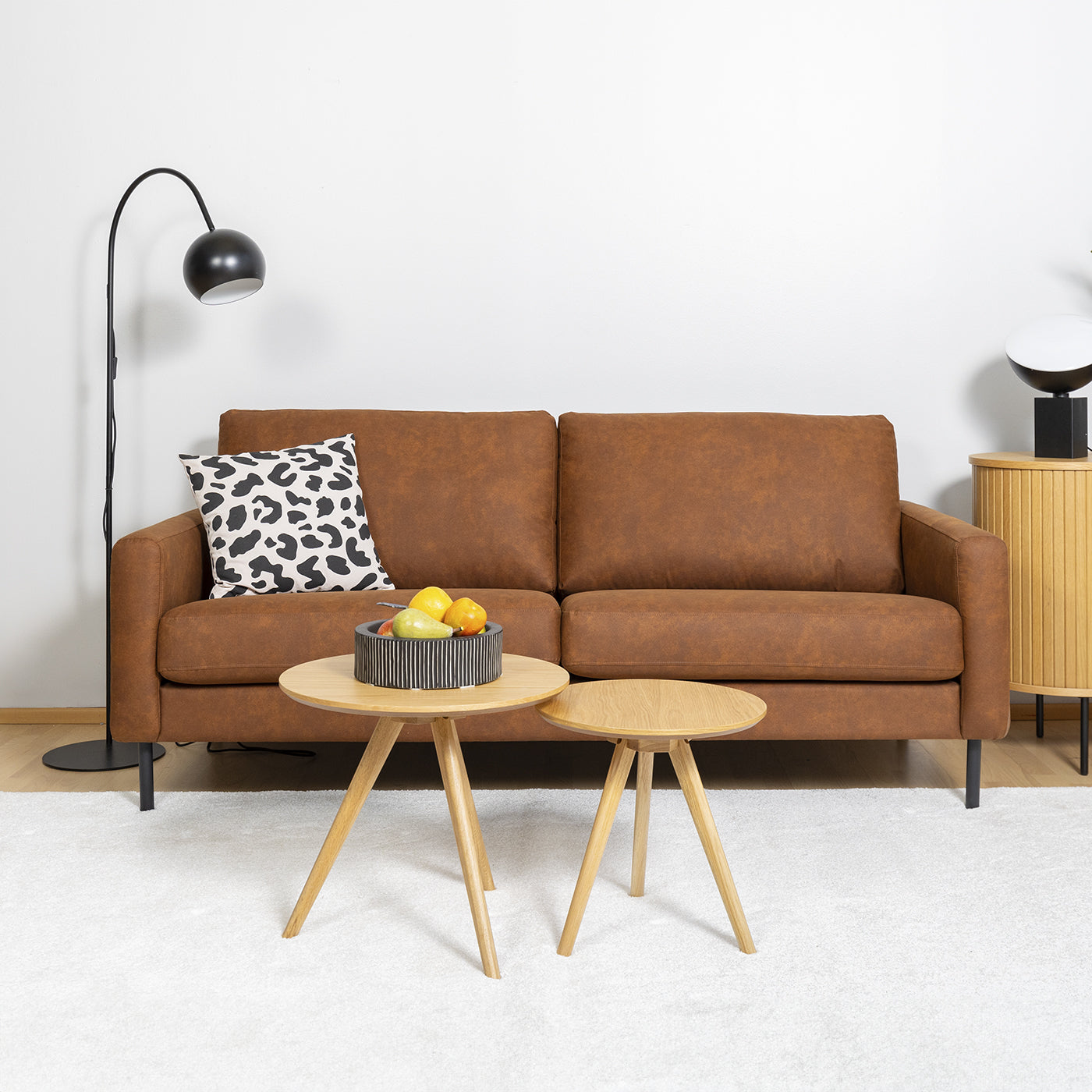 Kuvan Mila sohva-miljöössä Etualalla Rowicon Yumi-sarjapöytä ja oikealla Nola-senkki.