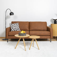 Kuvan Mila sohva-miljöössä Etualalla Rowicon Yumi-sarjapöytä ja oikealla Nola-senkki.