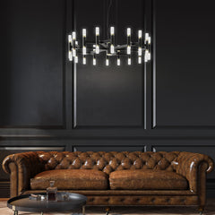 Kuvassa on Tribute-kattovalaisin mattamustalla rungolla, ylellisillä messinkiyksityiskohdilla ja eleganteilla opaalivalkoisilla valaisinputkilla. Kattokruunu on TRIAC-himmennettävä.