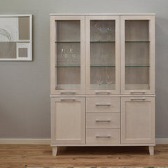 Kuvassa on kuultovalkoinen Vuokatti-vitriini. Vitriinissä on lasikaapisto lasihyllyillä, alaosan tilava senkki kaappien peiliovilla, sekä pitkänmalliset RST-vetimet. Lasikaapin sisällä olevat viinilasit eivät kuulu hintaan.