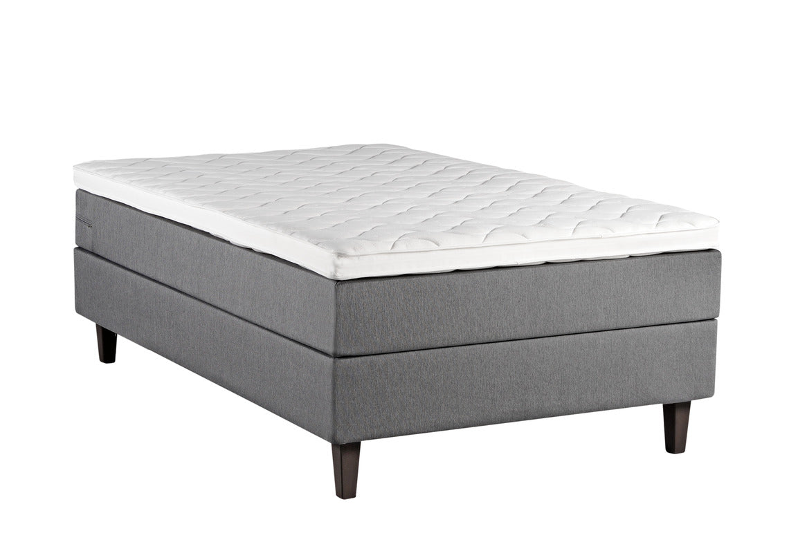 Harmaa Meri-jenkkisänky wengenvärisillä Royal-tammijaloilla ja profiloidulla sijauspatjalla.