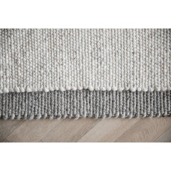 Lähikuva luonnonvalkoisesta ja harmaasta Auckland-villamatosta.