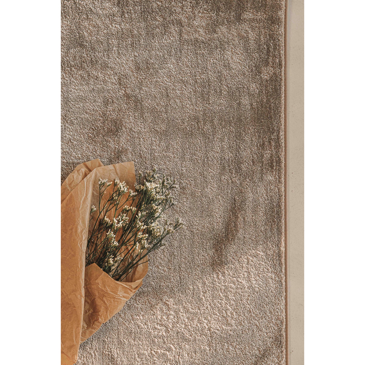 Pehmeässä Basaltti-nukkamatossa on elävä nukkapinta. Kuvassa on beige matto.