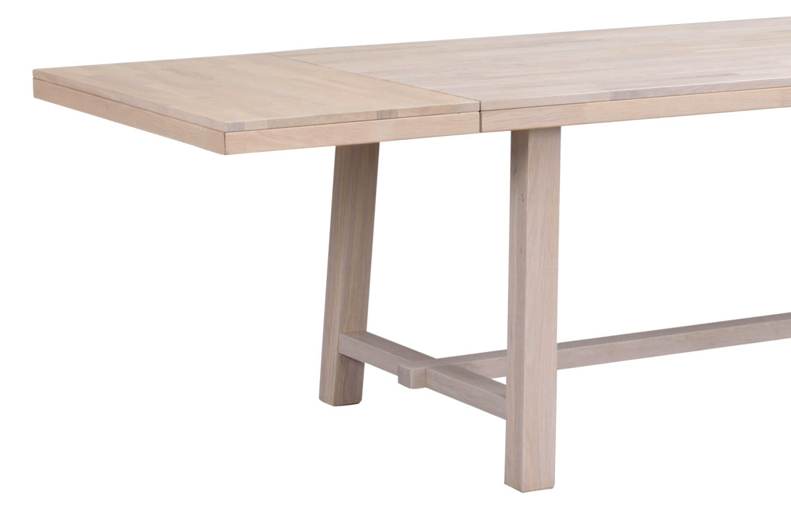 Kuvassa Brooklyn-ruokapöytä ja jatkolevy, väri valkotammi. Valkotammenvärinen massiivitammipinta on valkoöljytty ja siinä on sileä pinta.