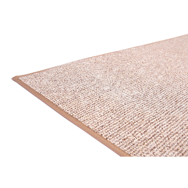 Lähikuvassa tuftatun Duuri-maton beige pinta ja reunakanttaus.