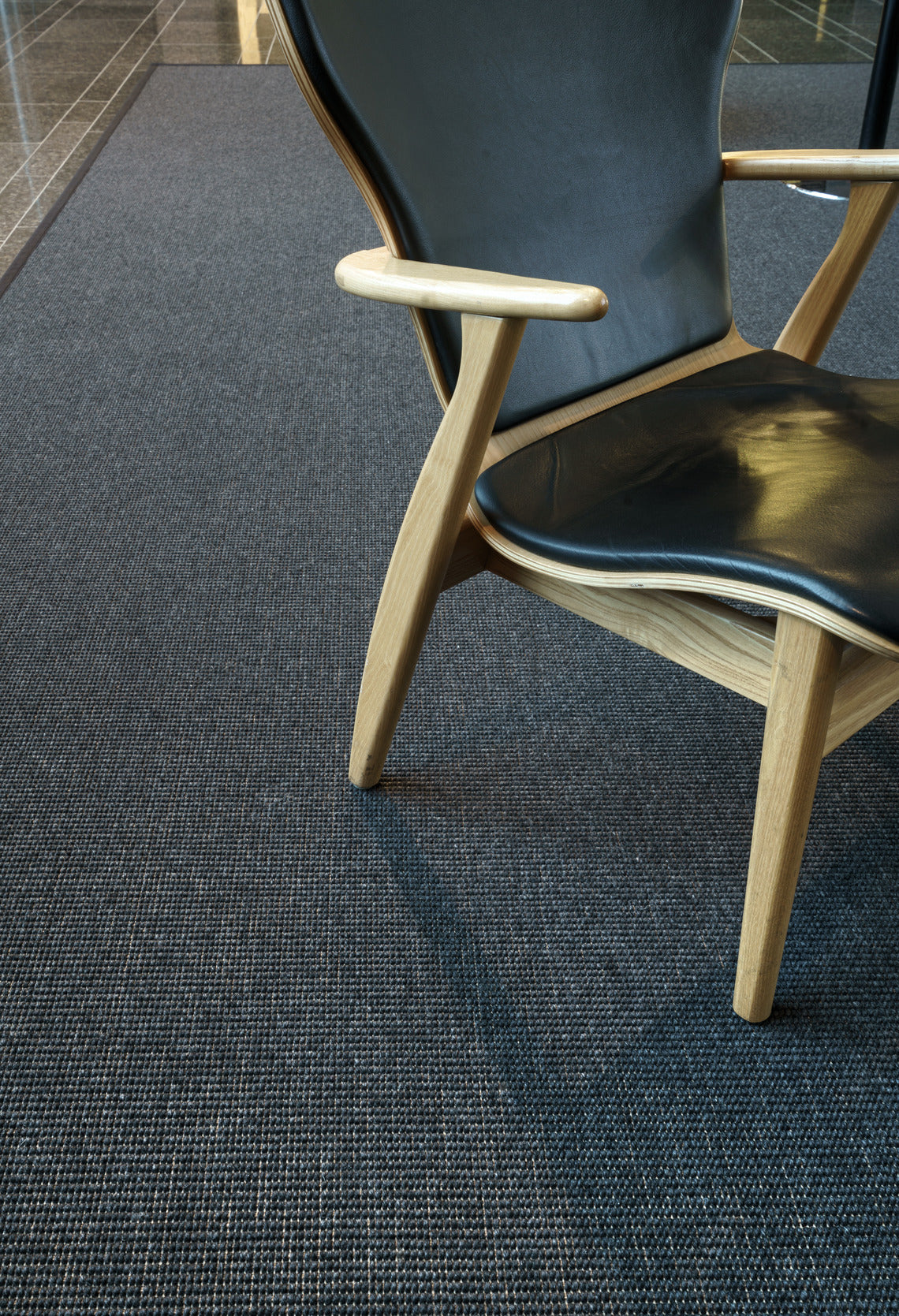 Matto on käsitelty likaa hylkiväksi ja reunat on kantattu chenille -kantilla. Kuvassa musta matto kapealla kanttauksella..