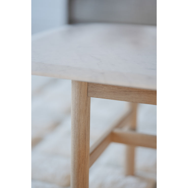 Ylellinen marmorikantinen Hammond-sohvapöytä on trendikäs ja kaunis. Lähikuvan valkokantisessa sohvapöydässä on valkotammiset jalat.