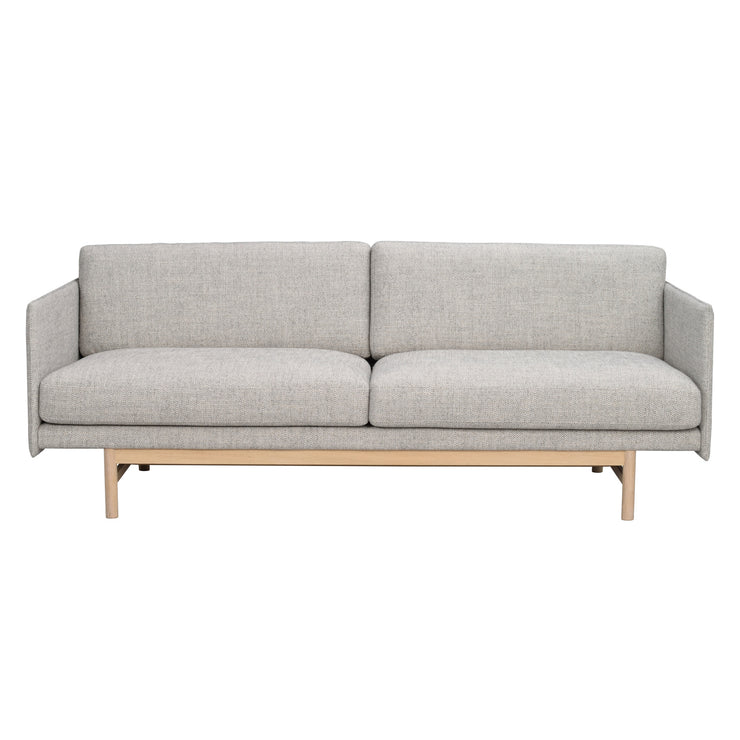 Hammond 3-istuttava sohva harmaalla kangasverhoilulla ja valkotammenvärisellä jalkaosalla.