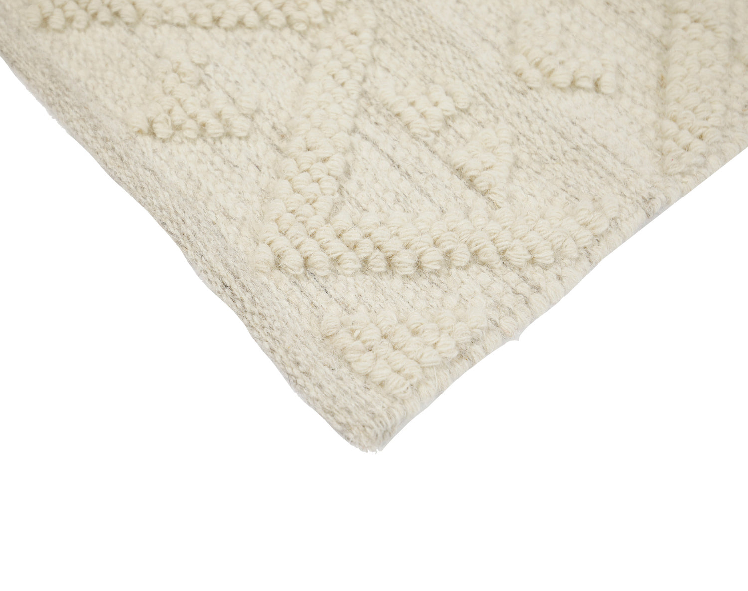 Lähikuvassa käsinkudotun Helmi-villamaton luonnonvalkoista kohokuvioitua villapintaa.