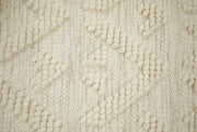 Lähikuvassa käsinkudotun Helmi-villamaton luonnonvalkoista kohokuvioitua villapintaa.