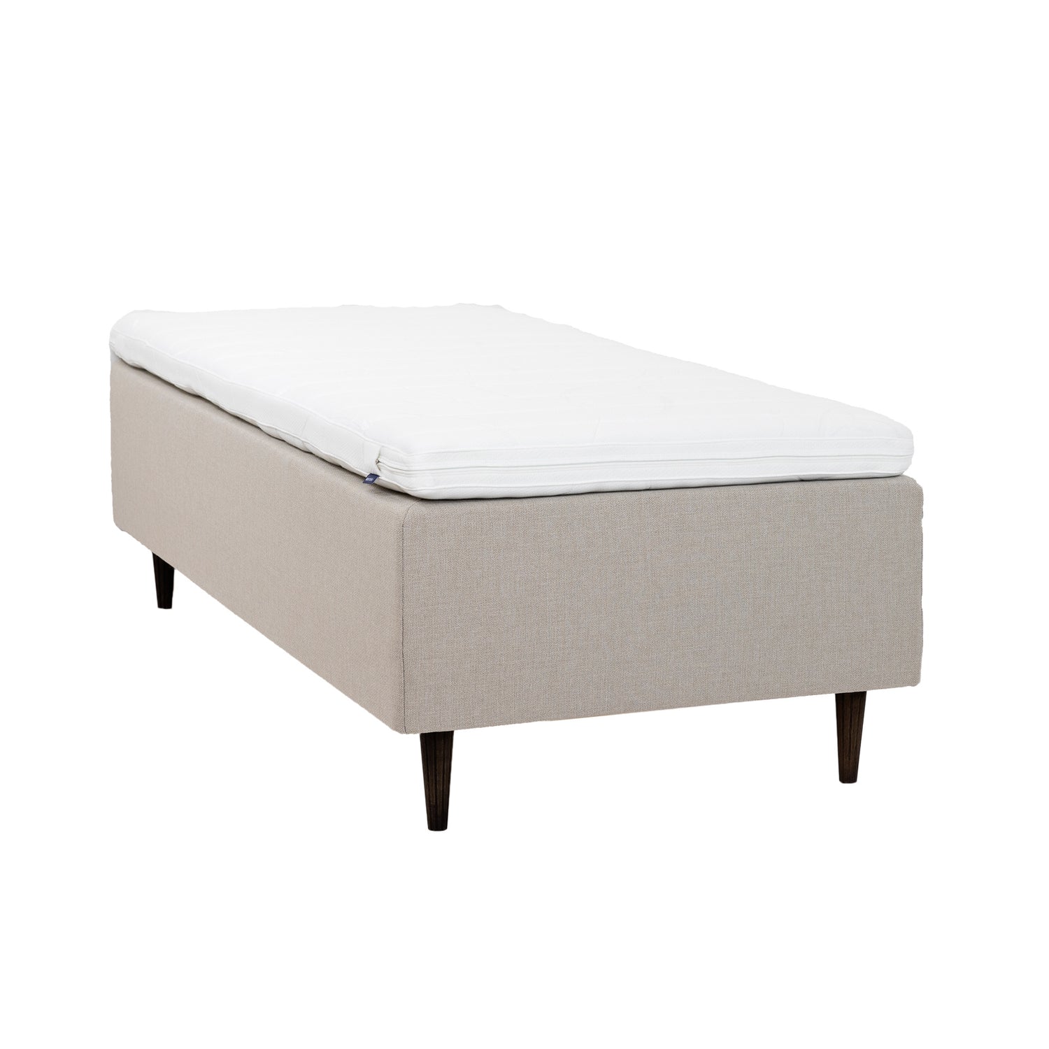 Beigenvärinen Hilding Cross -runkopatja 80 x 200 cm tummanruskeilla 23 cm korkeilla pyöreillä Hilding Raita -tammijaloilla ja Hilding Ergo -sijauspatjalla.