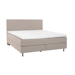 Beige Hilding Feel Ergo -jenkkisänky 160 x 200 cm mustilla pyöreillä 14 cm alumiinijaloilla ja Hilding Ergo -sijauspatjalla. Kuvan sileä Original -sängynpääty myydään erikseen.