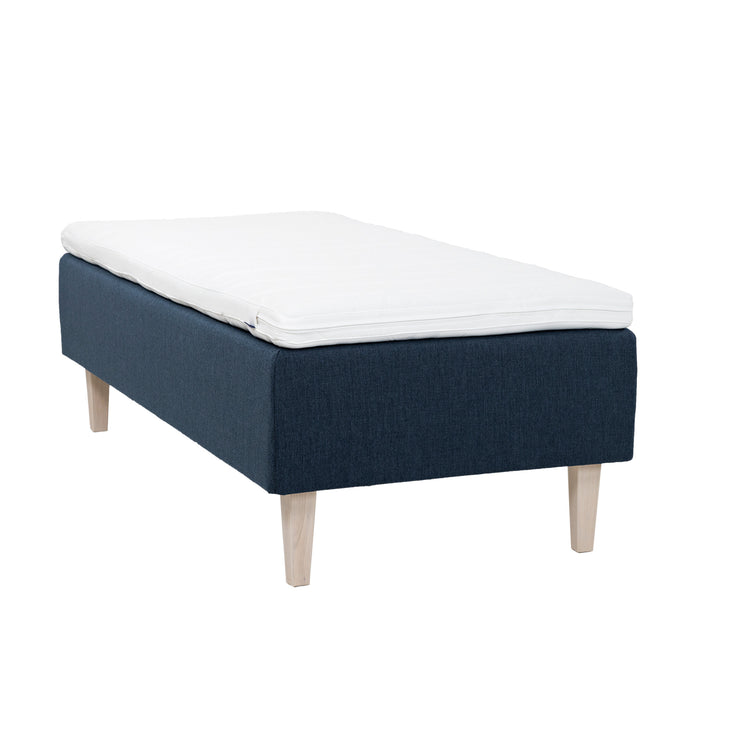 Sininen Hilding Feel Ergo -runkopatja 80 x 200 cm valkolakatuilla 23 cm korkeilla Royal -tammijaloilla ja Hilding Ergo -sijauspatjalla.