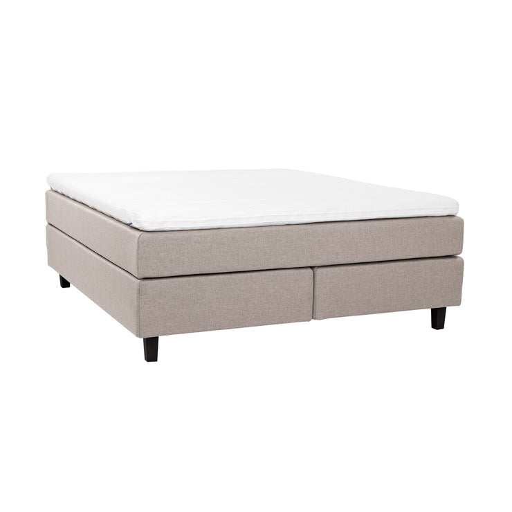 Beige Hilding Feel -jenkkisänky 160 x 200 cm hiilenmustilla 14 cm korkeilla Royal -tammijaloilla ja yhtenäisellä Hilding Hybrix Air Coolmax -sijauspatjalla.