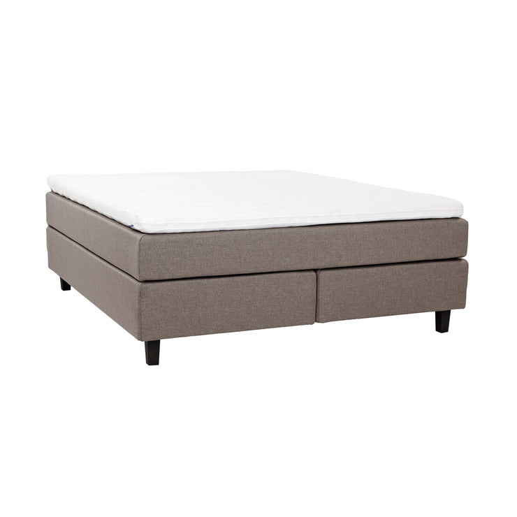 Hiekanvärinen Hilding Feel -jenkkisänky 160 x 200 cm hiilenmustilla 14 cm korkeilla Royal -tammijaloilla ja yhtenäisellä Hilding Hybrix Air Coolmax -sijauspatjalla.