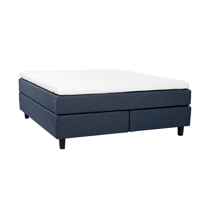 Sininen Hilding Feel -jenkkisänky 160 x 200 cm hiilenmustilla 14 cm korkeilla Royal -tammijaloilla ja yhtenäisellä Hilding Hybrix Air Coolmax -sijauspatjalla.