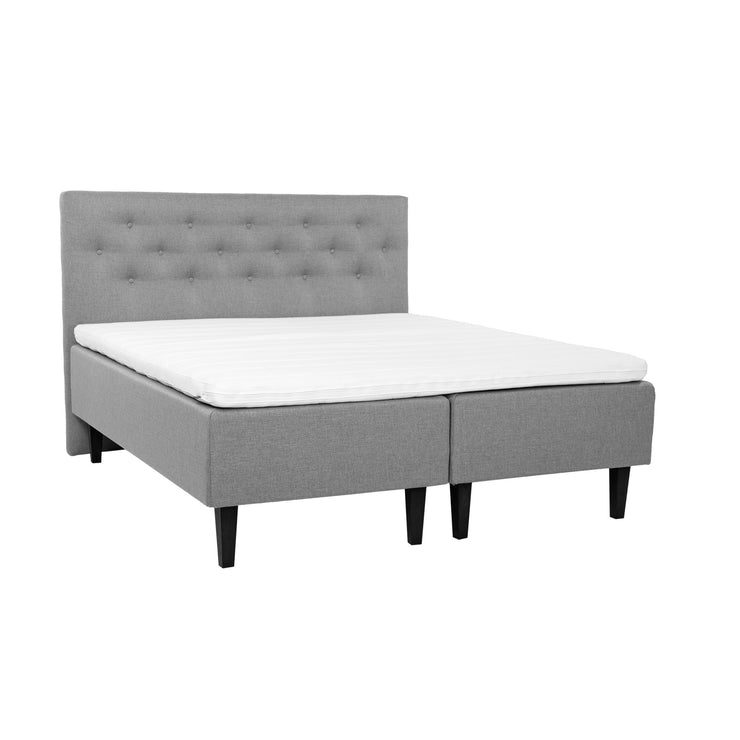 Harmaat Hilding Feel -runkopatjat hiilenmustilla 23 cm korkeilla Royal -tammijaloilla ja yhtenäisellä 180 x 200 cm Hilding Hybrix Air Coolmax -sijauspatjalla. Kuvan Feel -sängynpääty myydään erikseen.
