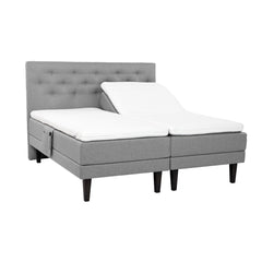 Harmaat Hilding Feel -moottorisängyt hiilenmustilla 23 cm korkeilla Royal -tammijaloilla ja erillisillä Hilding Hybrix Air Coolmax -sijauspatjoilla. Kuvan Feel -sängynpääty ja tarviketasku myydään erikseen.