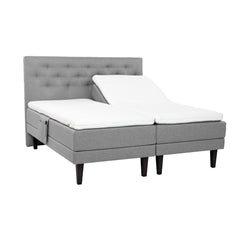 Harmaat Hilding Feel Ergo -moottorisängyt 90 x 200 cm hiilenmustilla 23 cm korkeilla Royal -tammijaloilla ja erillisillä Hilding Ergo -sijauspatjoilla. Kuvan Feel -sängynpääty ja tarviketasku myydään erikseen.