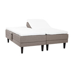 Hiekan väriset Hilding Feel -moottorisängyt hiilenmustilla 23 cm korkeilla Royal -tammijaloilla ja erillisillä Hilding Hybrix Air Coolmax -sijauspatjoilla. Kuvan tarviketasku myydään erikseen.