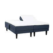 Siniset Hilding Feel -moottorisängyt hiilenmustilla 23 cm korkeilla Royal -tammijaloilla ja yhtenäisellä osittain halkaistulla 160 x 200 cm Hybrix Air Coolmax Split -sijauspatjalla. Kuvan tarviketasku myydään erikseen.