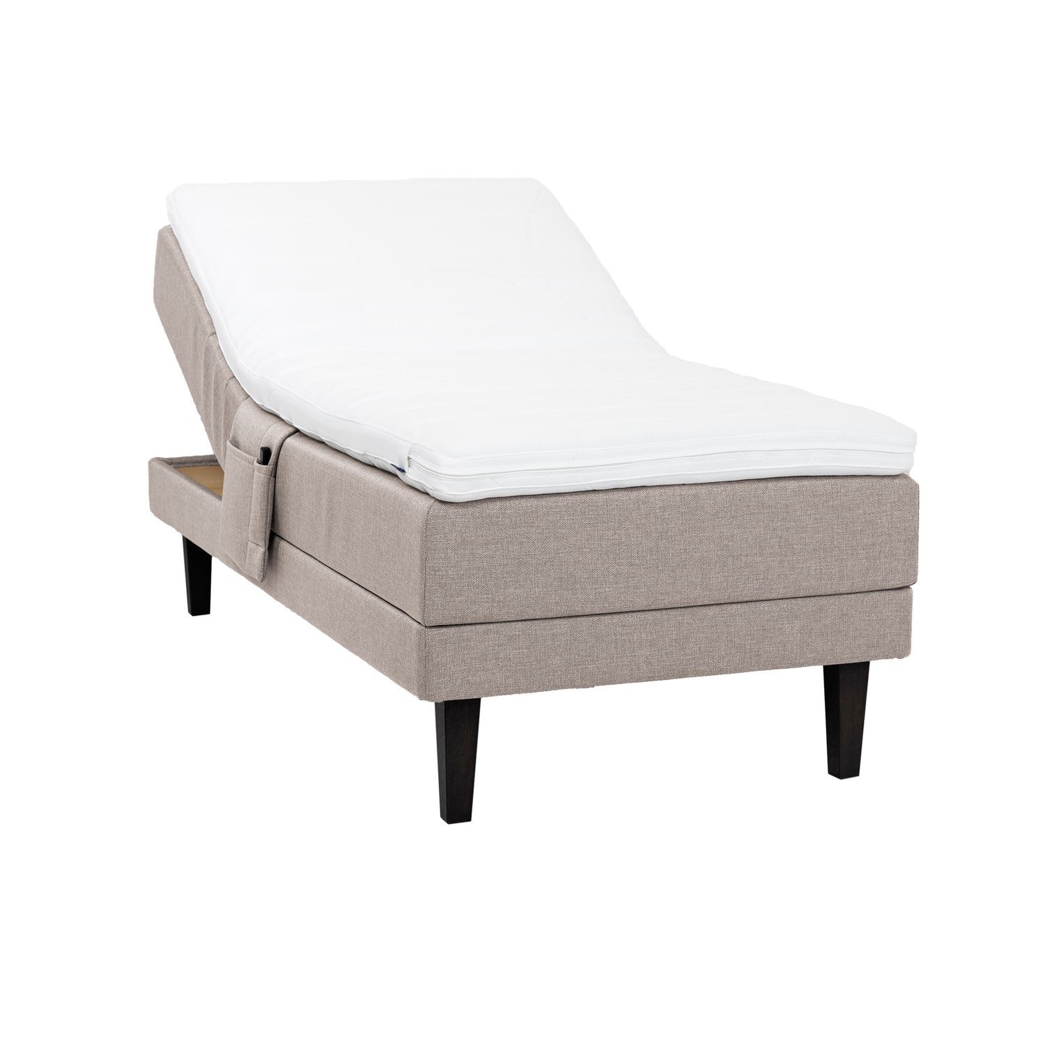 Beige Hilding Feel Ergo -moottorisänky 90 x 200 cm hiilenmustilla 23 cm korkeilla Royal -tammijaloilla ja Hilding Ergo -sijauspatjalla. Kuvan tarviketasku myydään erikseen.