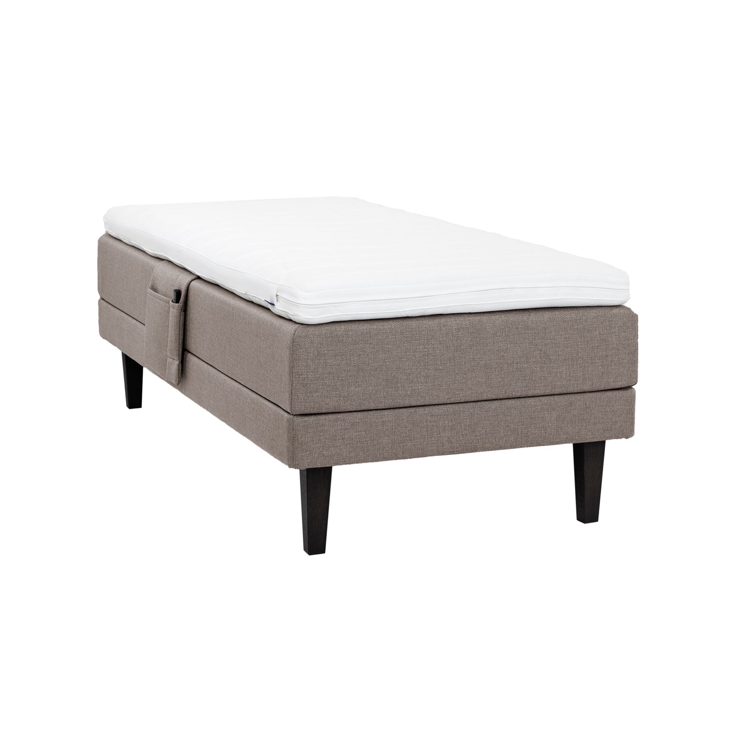 Hiekanvärinen Hilding Feel Ergo -moottorisänky 90 x 200 cm hiilenmustilla 23 cm korkeilla Royal -tammijaloilla ja Hilding Ergo -sijauspatjalla. Kuvan tarviketasku myydään erikseen.