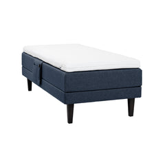 Sininen Hilding Feel Ergo -moottorisänky 90 x 200 cm hiilenmustilla 23 cm korkeilla Royal -tammijaloilla ja Hilding Ergo -sijauspatjalla. Kuvan tarviketasku myydään erikseen.