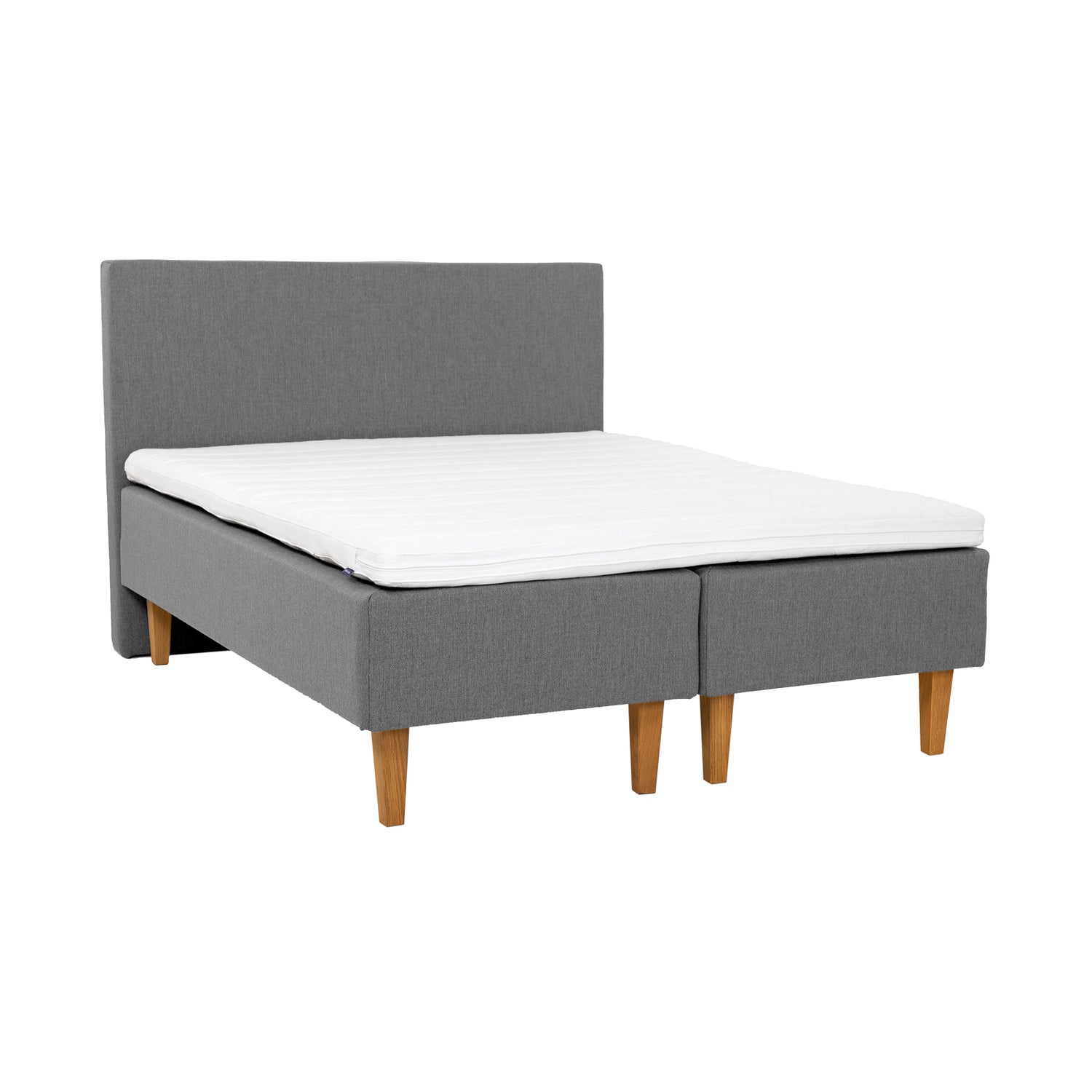 Harmaat Hilding Original -runkopatjat luonnonvärisillä 23 cm korkeilla Royal -tammijaloilla ja yhtenäisellä 180 x 200 cm profiloidulla Hilding kimmovaahtosijauspatjalla. Kuvan Original -sängynpääty myydään erikseen.