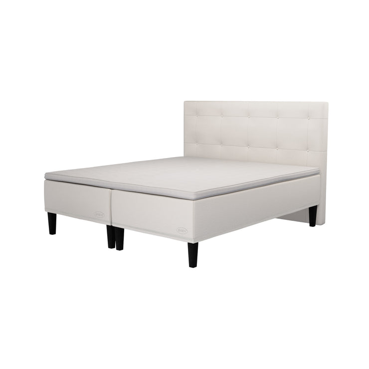 Jensen Carat -runkopatjat beigellä verhoiluvärillä ja nelikulmaisilla 23 cm korkeilla mustilla tammijaloilla. Yhtenäinen TempSmart -sijauspatja ja jalat sisältyvät hintaan. Virgo Decor -sängynpääty myydään erikseen.