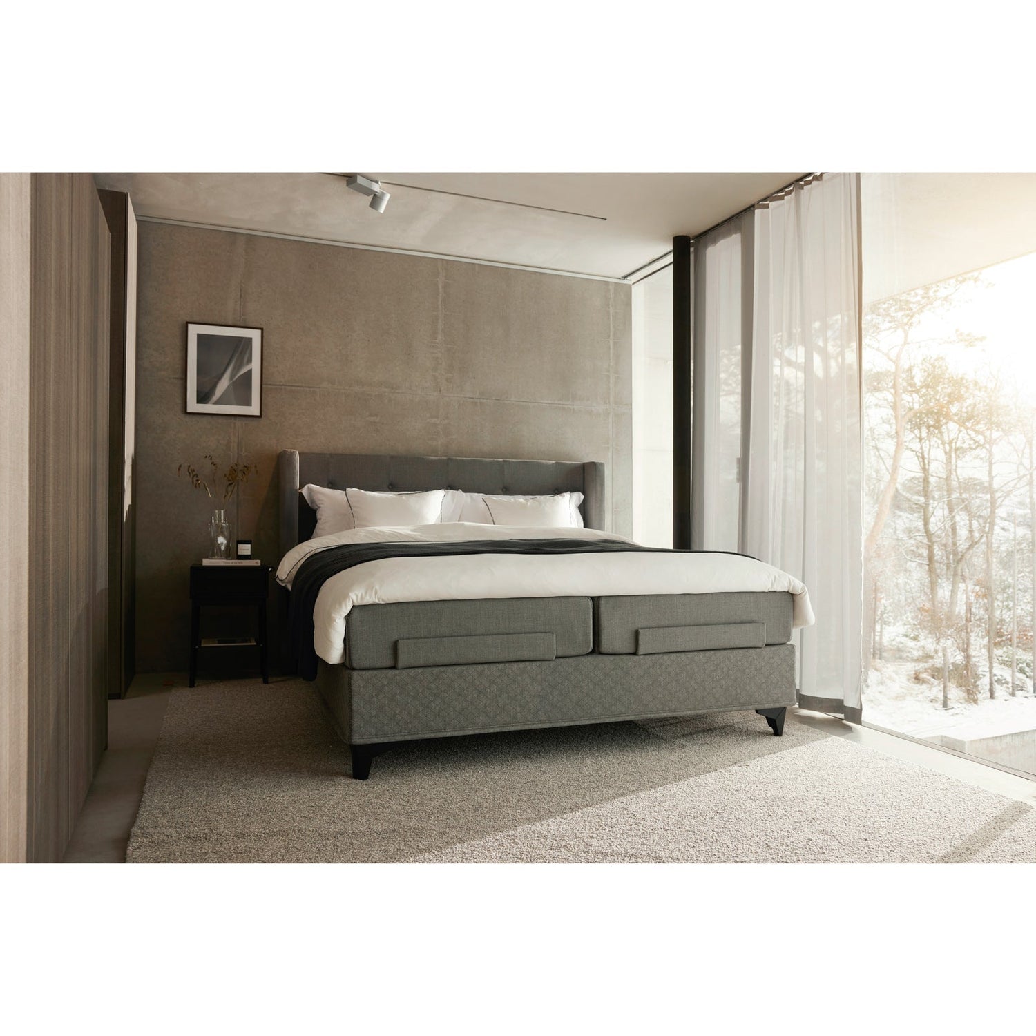 Jensen Majestic Aqtive II -moottorisänky on Nest-sängynpäädyn kanssa sisustuksellinen kokonaisuus, kuvassa on harmaa verhoiluväri ja mustat Eicon-jalat. Jensenin sängynpääty ja musta Eicon-yöpöytä myydään erikseen.