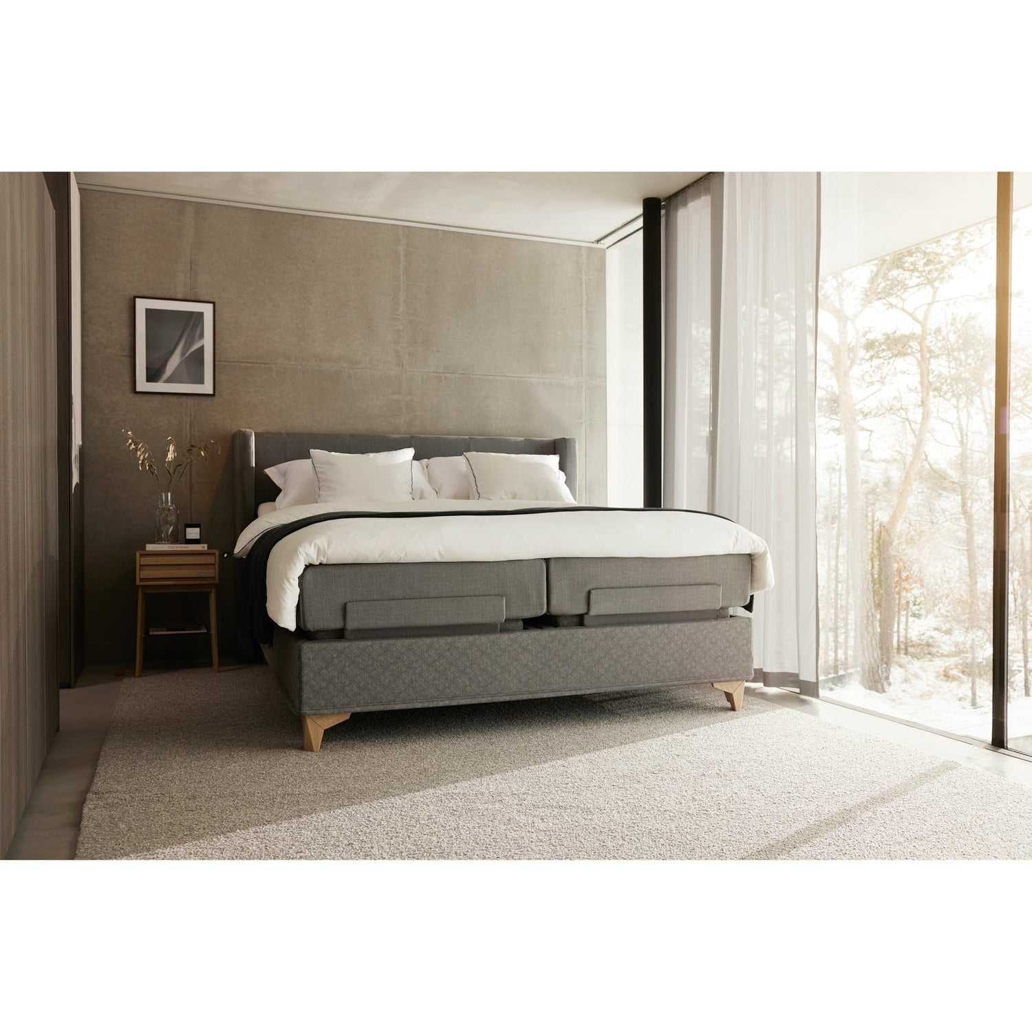 Jensen Majestic Aqtive II -moottorisänky on Nest-sängynpäädyn kanssa sisustuksellinen kokonaisuus, kuvassa on harmaa verhoiluväri ja valkotammenväriset Eicon-jalat. Jensenin sängynpääty valkotammenvärinen Eicon-yöpöytä myydään erikseen.