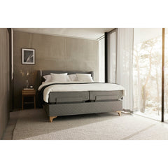 Jensen Majestic Aqtive II -moottorisänky on Nest-sängynpäädyn kanssa sisustuksellinen kokonaisuus, kuvassa on harmaa verhoiluväri ja valkotammenväriset Eicon-jalat. Jensenin sängynpääty valkotammenvärinen Eicon-yöpöytä myydään erikseen.