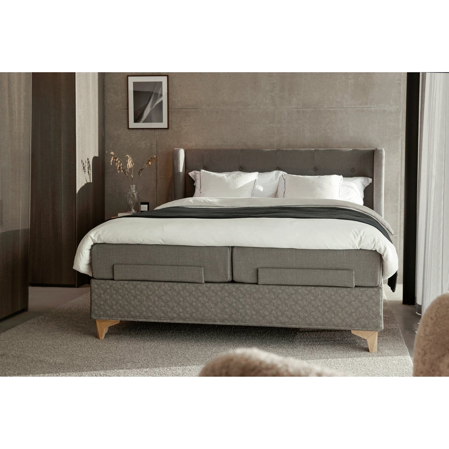 Jensen Majestic Aqtive II -moottorisänky on Nest-sängynpäädyn kanssa sisustuksellinen kokonaisuus, kuvassa on harmaa verhoiluväri ja valkotammenväriset Eicon-jalat. Jensenin sängynpääty valkotammenvärinen Eicon-yöpöytä myydään erikseen.